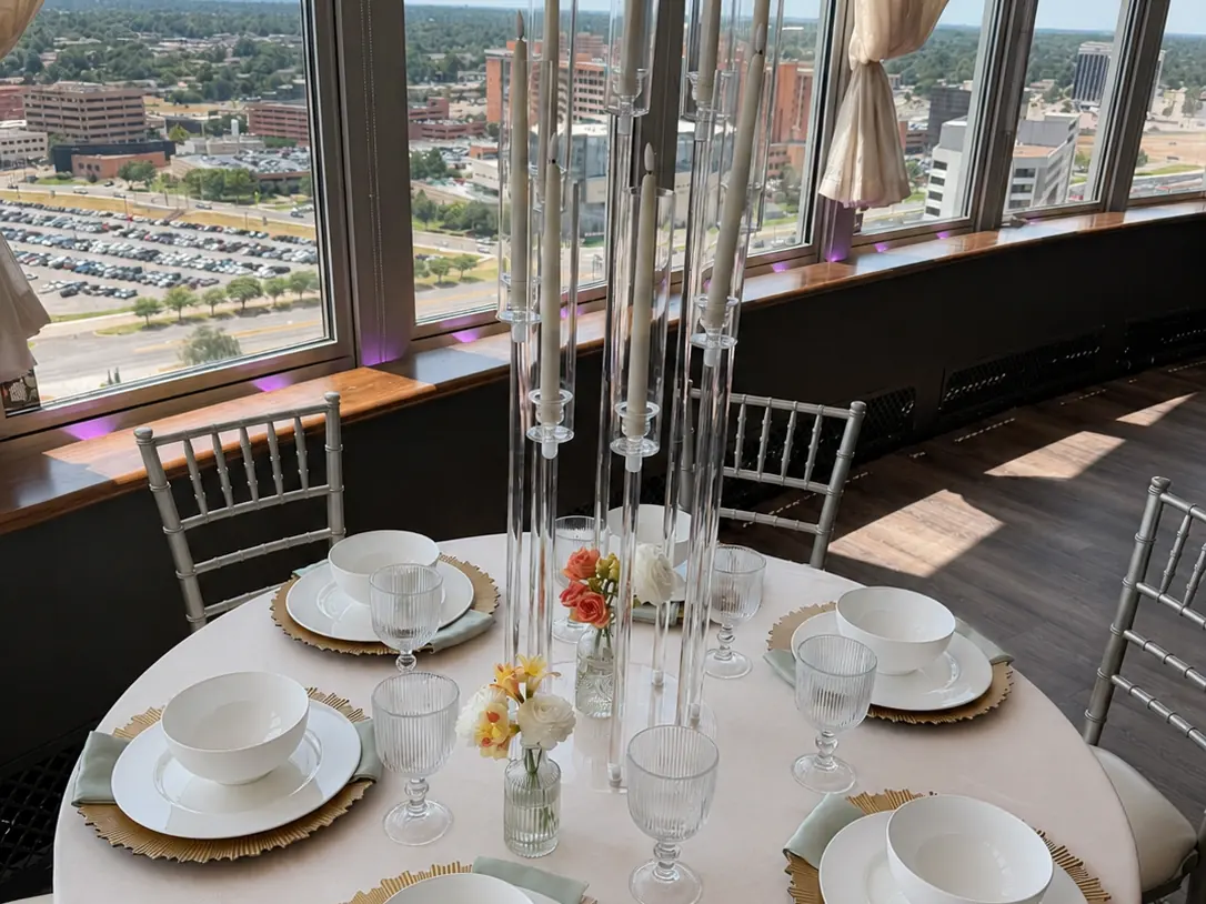 Champagne tablecloth with gold sunburst chargers, white china and candelabras overlooking Oklahoma City