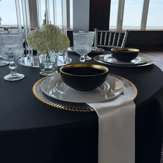 Black and gold bowls on white porcelain over a black tablecloth